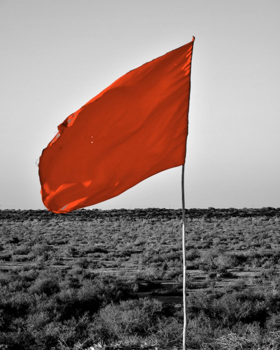Bandeira laranja fincada num campo aberto